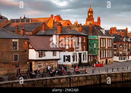 Pubs, Uhrenturm und Gemeinschaftsgeist am Ouse River im mittelalterlichen York, England. Stockfoto