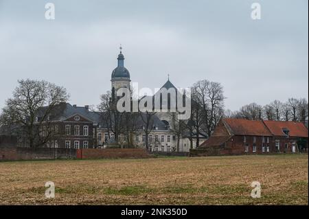 Kessel-Lo, Flämisches Brabant, Belgien - Februar 11 2023 - Bauernland, Bäume und der Turm der Abtei Vlierbeek im Hintergrund Stockfoto