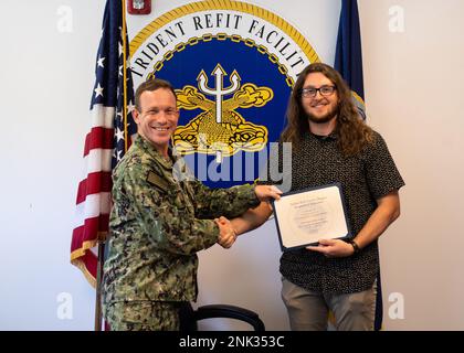 SILVERDALE, Washington (11. August 2022) – USA Navy Capt. Michael D. Eberlein, Commanding Officer, Trident Refit Facility, Bangor (TRFB), präsentiert Nicholas D. Allen, Shop 35A Supervisor, mit einem Zertifikat über den Abschluss des TRFB Leadership Development Program. Das TRFB Leadership Development Program bietet umfassende Schulungen zu Flottenwartungsfunktionen für aktuelle und zukünftige Führungskräfte des Kommandos. Stockfoto