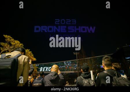 (230223) -- BUSAN, 23. Februar 2023 (Xinhua) -- Leute sehen eine Drohnen-Lichtshow im Busan Exhibition & Convention Center (BEXCO) in Busan, Südkorea, 23. Februar 2023. Im Rahmen der Drone Show Korea 2023, die am Donnerstag in der Stadt stattfindet, veranstalteten 500 Drohnen nachts eine Lichtshow über dem Messezentrum. Die Ausstellung der unbemannten Luftfahrzeuge (UAV) begann hier, um die neuesten Technologien und Modelle zu präsentieren und die Zukunft der Branche zu diskutieren. (Xinhua/Wang Yiliang) Stockfoto