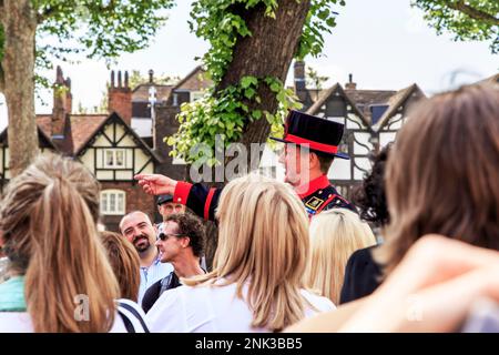 LONDON, GROSSBRITANNIEN - 16. MAI 2014: Ein nicht identifizierter Beefeater führt einen Ausflug im Tower of London durch. Stockfoto