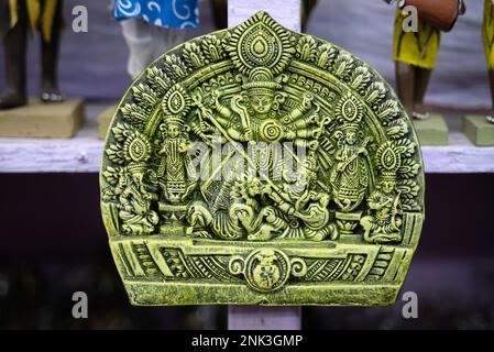 Die wunderschöne handgefertigte Skulptur der Göttin devi Durga wird in einem Geschäft mit verschwommenem Hintergrund zum Verkauf angeboten. Indische Kunst und Kunsthandwerk. Stockfoto