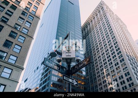 New York, USA - 25. November 2022: NYPD-Kamera über Straßenschildern an der Ecke Broadway und Liberty St., eine von über 15.000 NYPD-Überwachungen Stockfoto