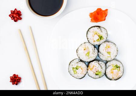 Lustiger essbarer Weihnachtsbaum, von Sushi-Brötchen, auf weißem Hintergrund. Kreative Idee für ein japanisches Restaurant. Das Konzept der Ernährung für das neue Jahr und ch Stockfoto