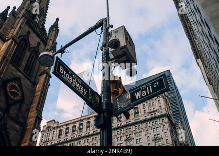 New York, USA - 25. November 2022: NYPD-Kamera über Straßenschildern an der Ecke Broadway und Wall Street. Einer von über 15.000 NYPD-Überwachern Stockfoto