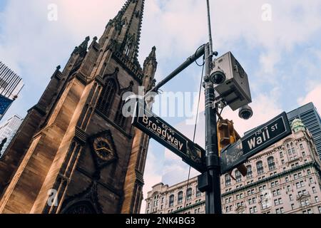 New York, USA - 25. November 2022: NYPD-Kamera über Straßenschildern an der Ecke Broadway und Wall Street. Einer von über 15.000 NYPD-Überwachern Stockfoto