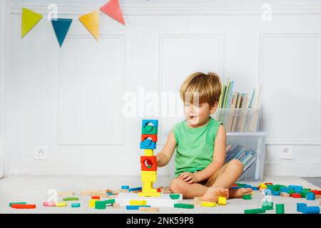 Bausteinturm für kleine Jungen, Spielzeug und Bücher in der Nähe Stockfoto