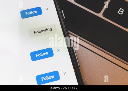 Schaltfläche "Folgen" in sozialen Netzwerken. Nahaufnahme von Makroaufnahmen auf dem Smartphone Stockfoto