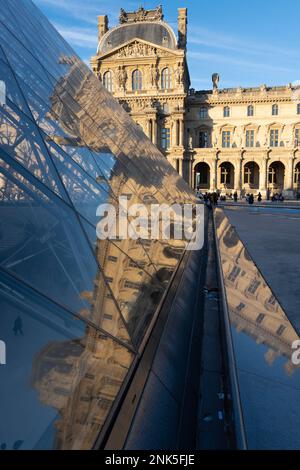 Paris, Frankreich - 02 21 2023: Reflexion der Fassade des Louvre-Museums auf der Louvre-Pyramide vom Napoleon-Innenhof Stockfoto