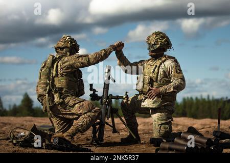 USA Army SPC. Joseph Smith, Left und USA Army SPC. Royland Reid, beide Infanteristen mit indirekter Feuerwehr, die der Viper Company zugeteilt wurden, 1. Bataillon, 26. Infanterie-Regiment, 2. Brigaden-Kampfteam, 101. Luftangriff, nach erfolgreicher Feuerwehr zur Unterstützung des Manövers des Unternehmens während einer multinationalen Feuerübung auf dem Rovaniemi-Trainingsgelände, Finnland, 11. August 2022. Die LFX war Teil der finnischen Sommerübung, bei der die US-amerikanischen und finnischen Truppen die Möglichkeit hatten, gemeinsam zu trainieren, um die Partnerschaft und den Interoper zu verstärken und zu stärken Stockfoto