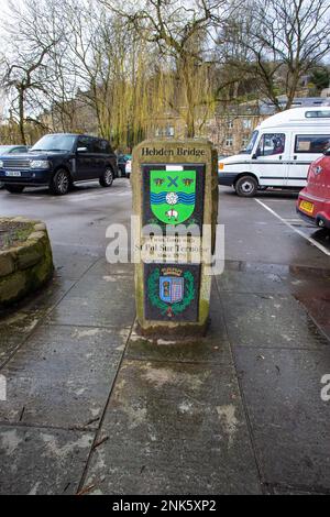 Zwei Stadtplaketten auf einer Steinsäule in Hebden Bride kennzeichnen die Partnerschaft der Stadt mit St. Pol Sur Ternoise am Brückentor seit 1979 Stockfoto