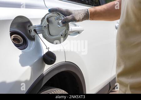 Der Fahrer öffnet die Luke des Gastanks. Auftanken des Autos. Tankwagen Stockfoto