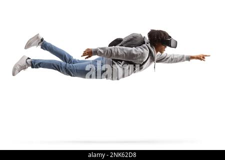 Aufnahme eines afroamerikanischen Studenten in voller Länge, der fliegt und ein VR-Headset trägt, isoliert auf weißem Hintergrund Stockfoto