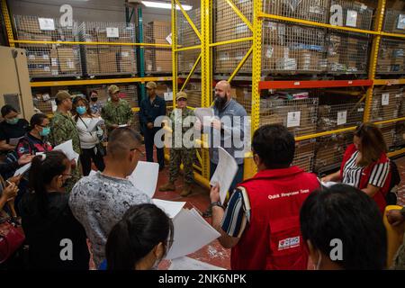 PUERTO PRINCESA, Philippinen (11. August 2022) – Charles Elliott, Lagerleiter an Bord des Krankenhausschiffs USNS Mercy (T-AH 19), Middle, leitet eine Supply Chain-Tour für humanitäre Hilfe und Katastrophenhilfe an Bord von Mercy zur Unterstützung der Pacific Partnership 2022. Die Pazifikpartnerschaft ist die größte multinationale Mission zur Vorbereitung auf humanitäre Hilfe und Katastrophenhilfe, die jährlich im Indo-Pazifik durchgeführt wird. Sie ist seit 17. Jahren Teil der Partnerschaft. Stockfoto