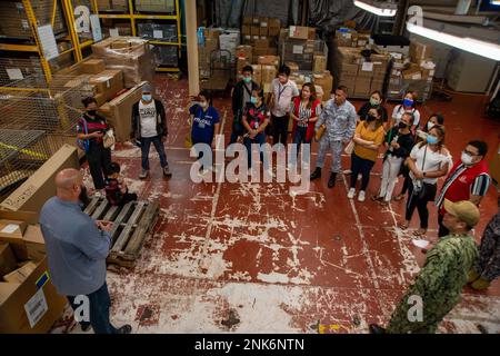 PUERTO PRINCESA, Philippinen (11. August 2022) – Charles Elliott, Lagerleiter an Bord des Krankenhausschiffs USNS Mercy (T-AH 19), unten links, leitet eine Supply Chain Tour für humanitäre Hilfe und Katastrophenhilfe an Bord von Mercy zur Unterstützung der Pacific Partnership 2022. Die Pazifikpartnerschaft ist die größte multinationale Mission zur Vorbereitung auf humanitäre Hilfe und Katastrophenhilfe, die jährlich im Indo-Pazifik durchgeführt wird. Sie ist seit 17. Jahren Teil der Partnerschaft. Stockfoto