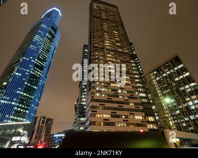 Moskau, Russland - 15. Februar 2023: Blick von unten auf die Turmgebäude im Geschäfts- und Finanzviertel der Stadt Moskau am Abend Stockfoto