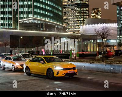 Moskau, Russland - 15. Februar 2023: Verschiedene Taxis fahren nach dem Ende des Arbeitstages abends im Geschäfts- und Finanzviertel der Stadt Moskau Stockfoto