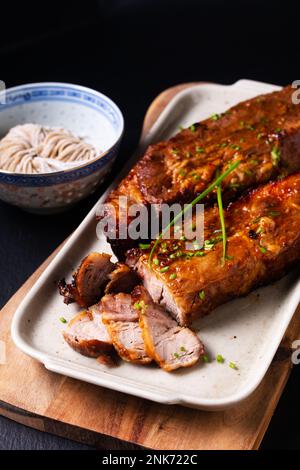 Speisekonzept hausgemachtes Char siu gegrilltes Schweinefleisch im kantonesischen Stil auf schwarzem Steinhintergrund mit Kopierbereich Stockfoto