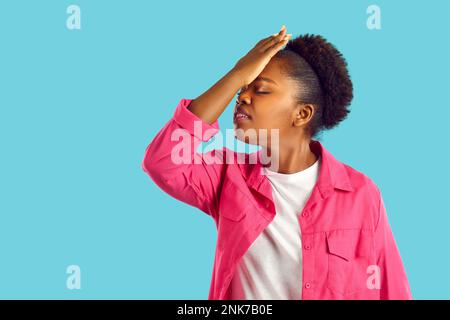 Junge afroamerikanische Frau zeigt Gesichts-Geste auf blauem Hintergrund. Stockfoto