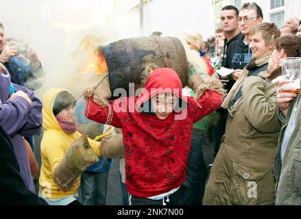 Junger Junge trägt Einen Burning Tar Barrel Ottery St. Mary Devon, Großbritannien Stockfoto