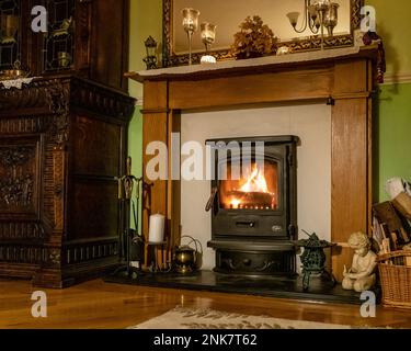 Gemütliches Winter Wohnzimmer Kamin, mit Holzofen, Großbritannien Haus innen. Stockfoto