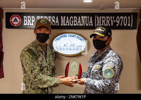 PUERTO PRINCESA, Philippinen (11. August 2022) – Kapitän Hank Kim, Befehlshaber der Pacific Partnership 2022 (PP22), Left, gibt Captain Erwin Tolentino, kommandierender Offizier des philippinischen Küstenwachschiffs BRP Teresa Magbanua (MRRV-9701), an Bord von Magbanua im Jahr PP22 eine Tafel. Die Pazifikpartnerschaft ist die größte multinationale Mission zur Vorbereitung auf humanitäre Hilfe und Katastrophenhilfe, die jährlich im Indo-Pazifik durchgeführt wird. Sie ist seit 17. Jahren Teil der Partnerschaft. Stockfoto