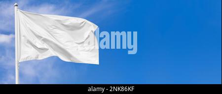 Weiße Fahne, die im Wind weht, auf Fahnenstange gegen den Himmel, mit Wolken am sonnigen Tag, Banner, Nahaufnahme Stockfoto