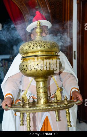 Ein Mann trägt Weihrauch während eines religiösen Rituals in Marokko Stockfoto