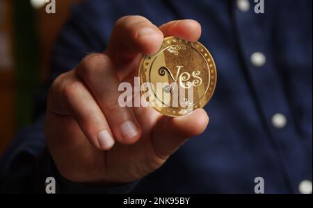 Ja oder Nein, wahllose Entscheidung und Spielverbot mit Goldmünze in Hand, abstraktes Konzept Stockfoto
