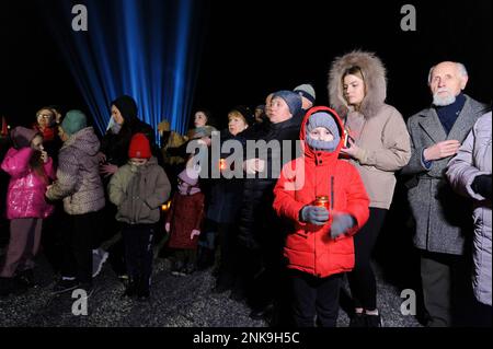 Lemberg, Ukraine 23. februar 2023. Familienmitglieder besuchen die Gräber gefallener Soldaten auf dem Friedhof Lychakiv, wo Hunderte ukrainischer Soldaten, die im letzten Jahr gestorben sind, bei einer Gedenkveranstaltung begraben werden, als symbolische „Strahlen der Erinnerung“ auf dem Militärfriedhof Lychakiv anlässlich des ersten Jahrestages des Bestehens von angezündet wurden Russlands Krieg gegen die Ukraine. Russland marschierte am 24. Februar 2022 in die Ukraine ein und löste damit den größten militärischen Angriff in Europa seit dem Zweiten Weltkrieg aus Stockfoto