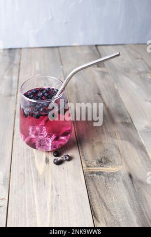 Limonadensaft aus Blaubeeren mit Eis. Kalte Getränke im Sommer vor dem Hintergrund eines grauen Holzhintergrunds. Stockfoto