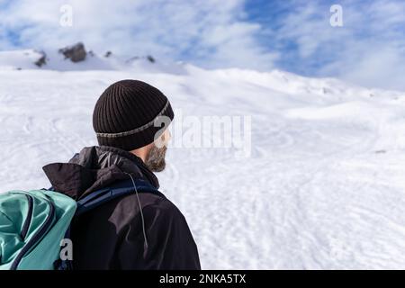 Mann im Rückblick wandert in einer herrlichen alpinen Winterberglandschaft. Haehlekopf, Berlingerskoepfle, Vorarlberg, Österreich. Stockfoto