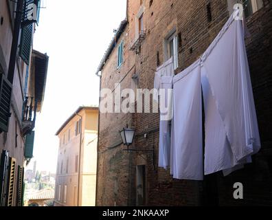 Kleider hängen in der Gasse einer alten italienischen Stadt in Südeuropa ohne Menschen Stockfoto