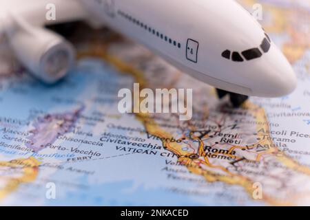 Passagierflugzeug auf einer Karte, das Rom, Italien, durch selektiven Fokus, Hintergrundunschärfe hervorhebt Stockfoto