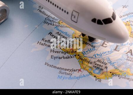 Passagierflugzeug auf einer Karte, das Reykjavik, Island, durch selektiven Fokus, Hintergrundunschärfe hervorhebt Stockfoto