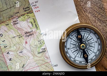 Nahaufnahme des Holztisches mit topografischer Karte, Kompass oben. Stockfoto