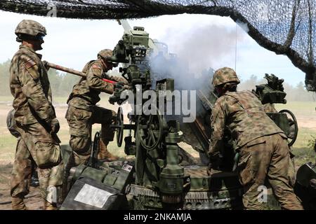 Von links, USA Armee-Sergeant Preston Hinger, USA Army SPC. Tyler Azer und USA Rebekah Engle, Cannon Crewmitglieder zugewiesen zu Charlie Battery, 1. Bataillon, 134. Artillerie-Regiment, räumen und bereiten einen M777 Howitzer vor, um während der jährlichen Trainingsübung Northern Strike, Camp Grayling, Michigan, 12. August 2022 eine weitere Runde abzufeuern. C Co. Schloss sich über 2.000 weiteren Soldaten und Truppen der Nationalgarde von Ohio und Michigan aus Großbritannien, Lettland und Ungarn an, um die Übung durchzuführen und den operativen Zusammenhalt zwischen den USA und ihren Verbündeten aufzubauen und aufrechtzuerhalten. Stockfoto