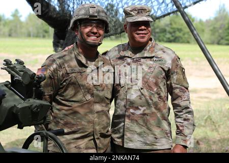 USA Mikael Floresmaldanado, Left, ein Cannon Crewmitglied, das Charlie Battery, dem 1. Bataillon, dem 134. Artillerie-Regiment und den USA zugeteilt ist Generalmajor John C. Harris, Jr., Adjutant General, Ohio Nationalgarde, Posieren Sie für ein Foto während der jährlichen Trainingsübung Northern Strike, Camp Grayling, Michigan, 12. August 2022. Harris nahm sich einen Moment Zeit, um Floresmaldanados Engagement für die Mission zu würdigen, als der Soldat alles daransetzte, um sicherzustellen, dass er rechtzeitig für das Training berichtete. Stockfoto