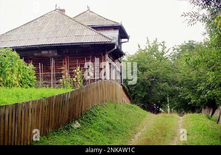 Malerische Landstraße vorbei an einem großen Holzhaus in Solonetu Nou, Suceava County, Rumänien, 2001 Stockfoto