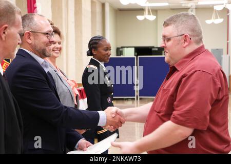 Chris Largent, Director of Home Base Operations am Rock Island Arsenal-Joint Manufacturing and Technology Center (links), überreicht Charles Hender ein RIA-JMTC Journeyman-Schlosserzertifikat nach seinem Abschluss vom Machinisten-Ausbildungsprogramm im August 12. Hender, einer von 10 neuen Journeyman-Mechanikern der Augustklasse 2022, absolvierte ein vierjähriges Programm, das akademische Ausbildung und praktische Ausbildung in allen betrieblichen Aspekten des Werks erforderte. Das 1910 gegründete „Machinist Apprentice Program“ bietet qualifizierten Handwerkern die Möglichkeit, die Aufgabe der Fabrik als Unterstützer fortzusetzen Stockfoto