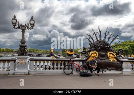 PARIS, FRANKREICH - August 15 2022: Straßenmusiker mit Saxophon auf der Brücke Pont Alexandre III in Paris, Frankreich Stockfoto