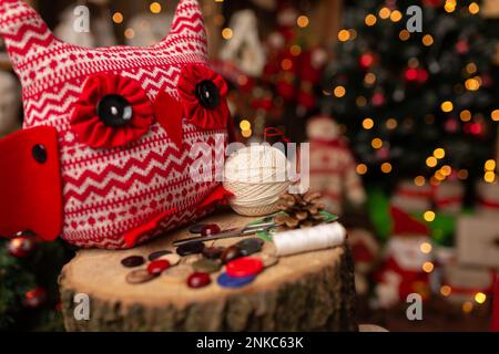 Großmutter näht eine weiche Eule im Weihnachtsgeschäft. Im Studio Stockfoto