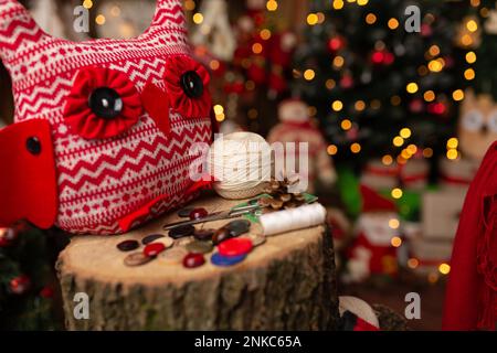 Großmutter näht eine weiche Eule im Weihnachtsgeschäft. Im Studio Stockfoto