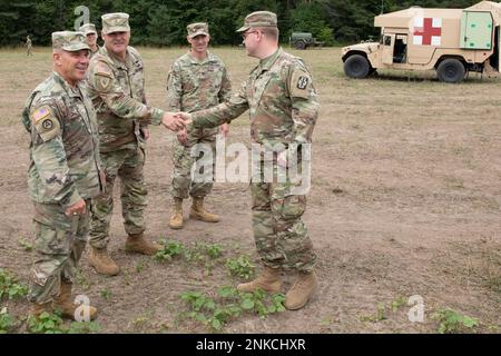USA Oberbefehlshaber der Armee 5 Patrick Nelligan, Oberbefehlshaber 5, USA Army Reserve Command, links, Chief Warrant Officer 5 Allen Robinson, Command Chief Oversight Officer, Michigan Army Nationla Guard, Und Oberst Gunnar Kiersey, stellvertretender Chirurg der Nationalgarde der Armee, trifft sich mit 1. LT. Thomas Moriarty, 477. Medical Company, Duluth Minn., um am 13. August 2022 während des Northern Strike im Camp Grayling Joint Maneuver Training Center in Grayling, Michigan, über den Einsatz von Krankenwagen zu sprechen. Northern Strike ist dafür bestimmt, über 7.400 Mitglieder des Dienstes mit verschiedenen Schulungsformen herauszufordern Stockfoto