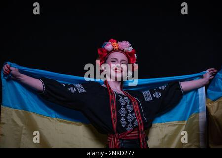 London, Großbritannien. 23. Februar 2023 Eine Frau in traditioneller ukrainischer Kleidung schließt sich den Demonstranten auf dem Trafalgar-Platz an, die zum ersten Jahrestag der russischen Invasion des Landes hierher gekommen sind. Kredit: Kiki Streitberger/Alamy Live News Stockfoto