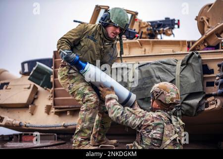 Bemowo Piskie, Polen. 16. Februar 2023. USA Army Staff Sgts. Ross Wilcoxson, links, und Marcus Kearse, rechts, beide M1 bewaffnete Crewmitglieder, die der Apache Company zugeteilt sind, 1. Bataillon, 9. Kavallerie-Regiment, 2. Panzerbrigade-Kampfteam, 1. Kavallerie-Division, laden Munition auf einen M1A2 Abrams-Panzer während einer Feuerübung in Bemowo Piskie, Polen, 16. Februar 2023. Die 4 ID und ihre unterstützenden Einheiten arbeiten stolz zusammen mit NATO-Verbündeten und regionalen Sicherheitspartnern daran, Kampfkräfte für das V-Corps, das US-amerikanische Forward Disponed Corps in Europa, bereitzustellen. (Kreditbild: © John Schoebel/USA A Stockfoto