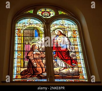 Buntglasfenster von St. Margaret Mary, eine Besuchsnonne aus Alacoque, Frankreich, die 1673 Visionen vom Heiligen Herzen Jesu erlebte. Stockfoto