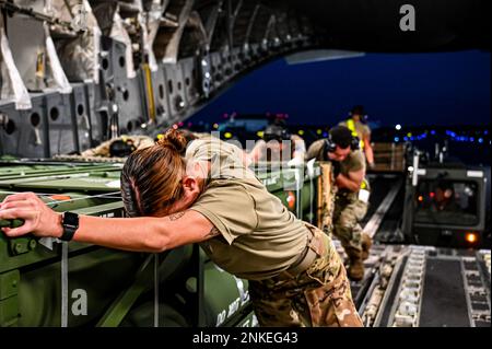 Senior Airman Natasha Mundt, Ladeschwader der 14. Luftwaffe und dem 305. Lufthafenschwadron zugeteilte Airmen bereiten den Upload von Guided Multiple Launch Rocket System Munition auf einen C-17 Globemaster III in Joint Base McGuire-Dix-Lakehurst, N.J., 13. August 2022 vor. Die Munitionsladung ist Teil eines zusätzlichen Hilfspakets für die Ukraine. Die von den USA für die Ukraine bereitgestellte Sicherheitshilfe ermöglicht einen kritischen Erfolg auf dem Schlachtfeld gegen die russische Invasionstruppe. Stockfoto