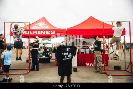 Jadyn Rogers, 14, und ein Pyramid Rock Young Marine posieren für ein Foto mit der Marine Corps Pull-up Challenge, nachdem sie 19 Pull-Ups bei der 2022 Kaneohe Bay Air Show, Marine Corps Air Station Kaneohe Bay, Marine Corps Base Hawaii, 14. August 2022 abgeschlossen haben. Die Flugschau wurde veranstaltet, damit die lokale Gemeinde, Mitglieder des Dienstes und Bewohner von MCBH während einer Weltklasse-Veranstaltung interagieren können. Die Kaneohe Bay Air Show mit Luftvorführungen, statischen Darstellungen, Vorführungen und Verkäufern sollte den Bewohnern Hawaiis die Wertschätzung von MCBH und ihre anhaltende Unterstützung durch die zum Ausdruck bringen Stockfoto