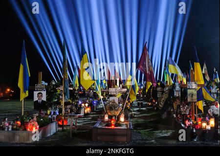 Lemberg, Ukraine. 23. Februar 2023. Gräber der gefallenen Soldaten auf dem Friedhof Lychakiv, wo Hunderte ukrainischer Soldaten, die im letzten Jahr gestorben sind, bei einer Gedenkveranstaltung begraben werden, da symbolische "Erinnerungsstrahlen" auf dem Militärfriedhof Lychakiv beleuchtet wurden, um den ersten Jahrestag des russischen Krieges gegen Russland zu feiern Ukraine. Russland marschierte am 24. Februar 2022 in die Ukraine ein und löste damit den größten militärischen Angriff in Europa seit dem Zweiten Weltkrieg aus Kredit: SOPA Images Limited/Alamy Live News Stockfoto